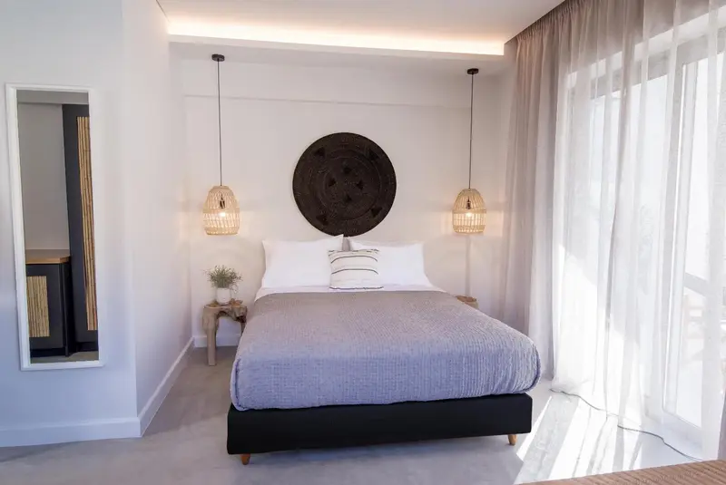 Une chambre lumineuse avec un grand lit et un décor mural.