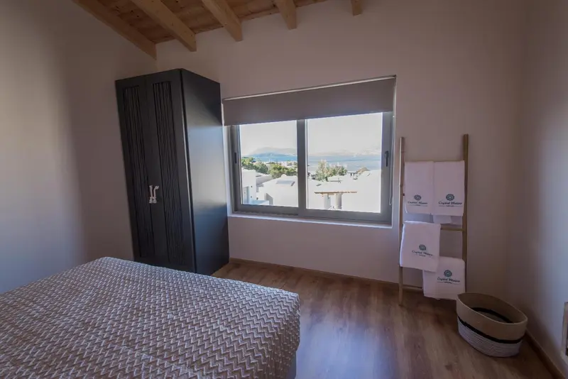 Une chambre lumineuse avec un lit et une vue sur la mer.