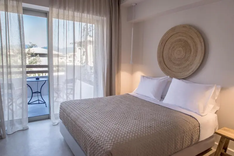 Une chambre lumineuse avec un lit et un accès à un balcon.