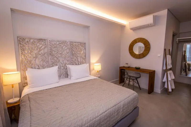 Une chambre lumineuse avec un grand lit et un espace bureau.