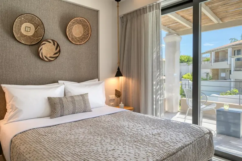 Une chambre lumineuse avec un grand lit et un accès à une terrasse.
