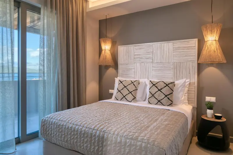 Une chambre lumineuse avec un grand lit et des lampes suspendues.