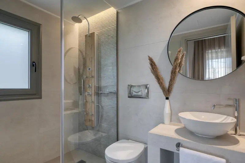 Une salle de bain moderne avec douche à l'italienne et vasque intégrée.