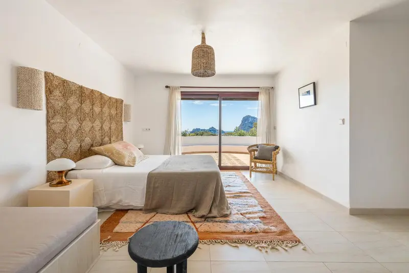 Une chambre lumineuse avec un grand lit et une vue sur un paysage montagneux.