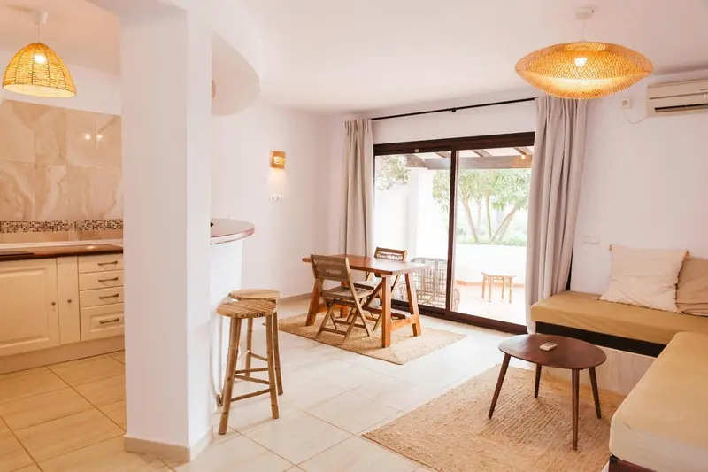 Espace de vie lumineux avec coin repas et canapé.