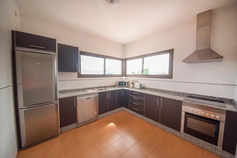 Cuisine moderne avec plan de travail en granit et électroménager en inox.