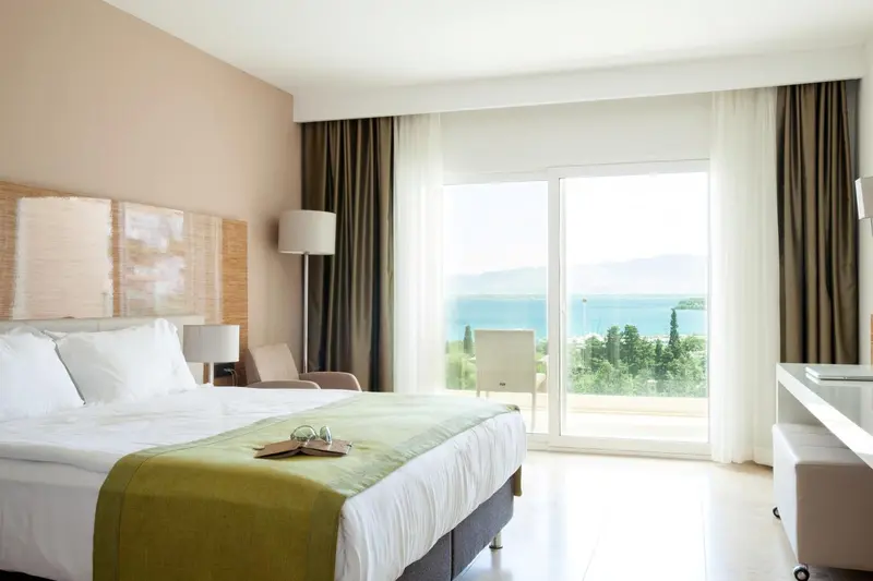 Une chambre lumineuse avec un grand lit et une vue sur la mer.