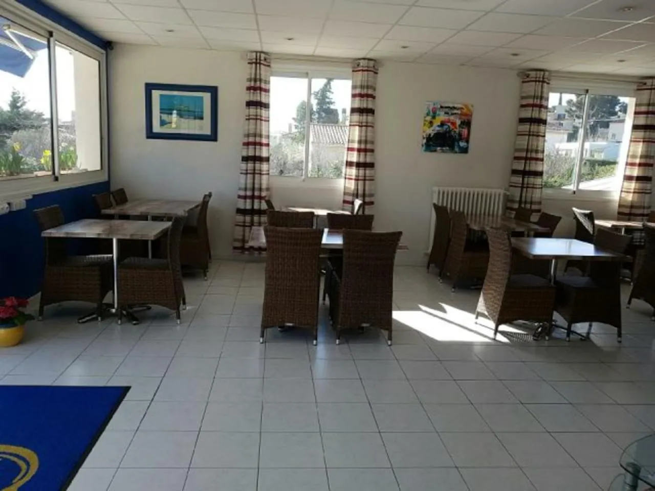 Une salle lumineuse avec des tables et des chaises pour les repas.