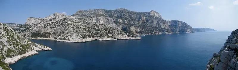 Vue panoramique sur une côte rocheuse et la mer bleue.