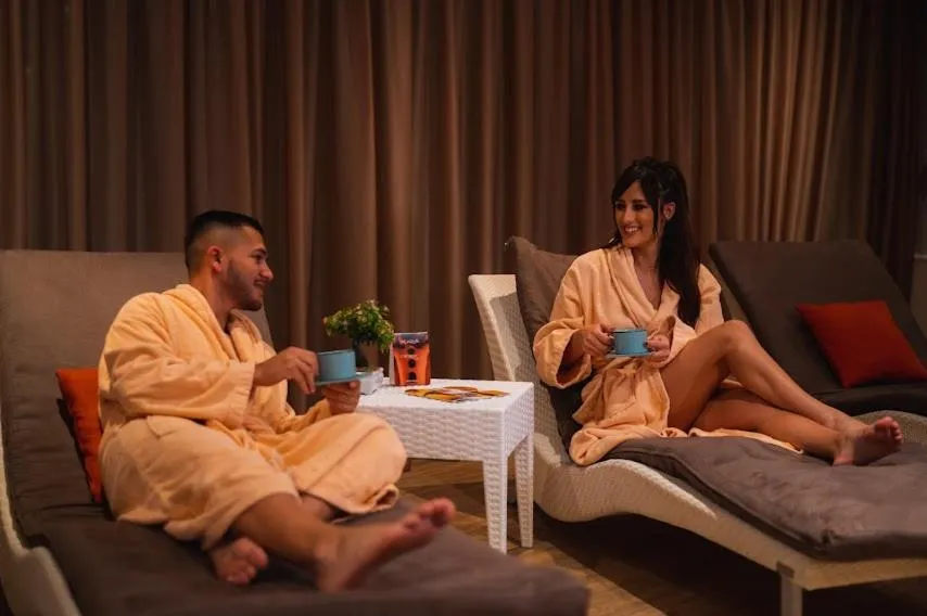 Un couple se détend sur des fauteuils confortables avec des boissons.
