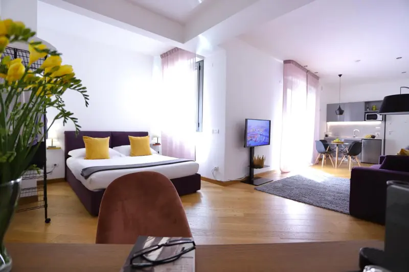 Une chambre avec un lit double et un espace salon attenant.