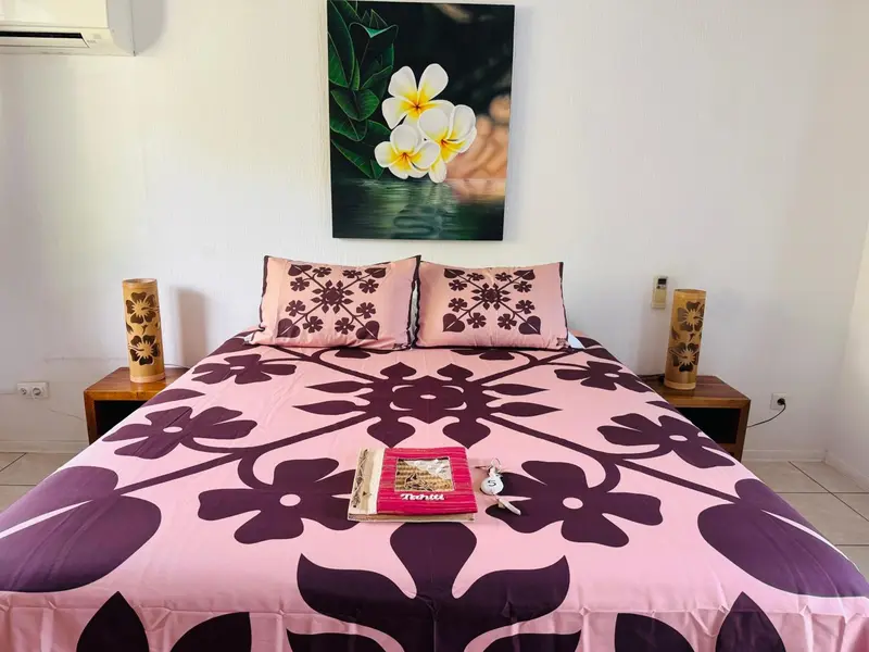 Lit recouvert d'une courtepointe à motifs floraux dans une chambre décorée.
