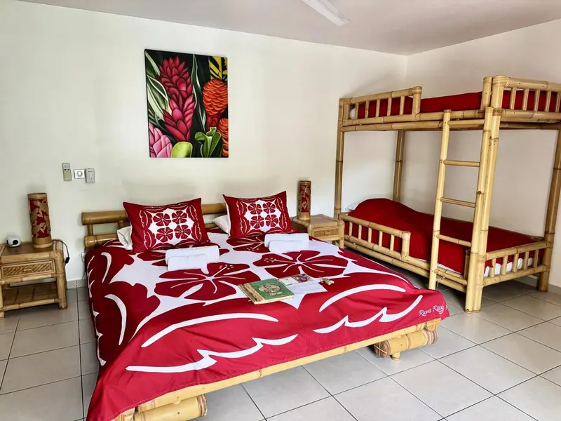 Une chambre avec un lit superposé et un lit double décorés de motifs floraux.