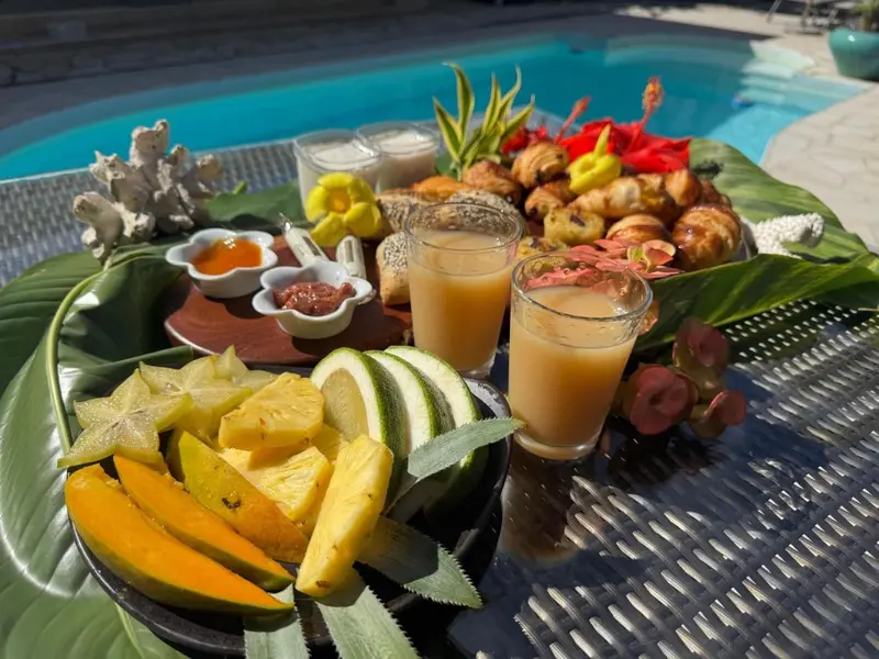 Présentation de plats exotiques et de boissons fraîches sur une table près d'une piscine.