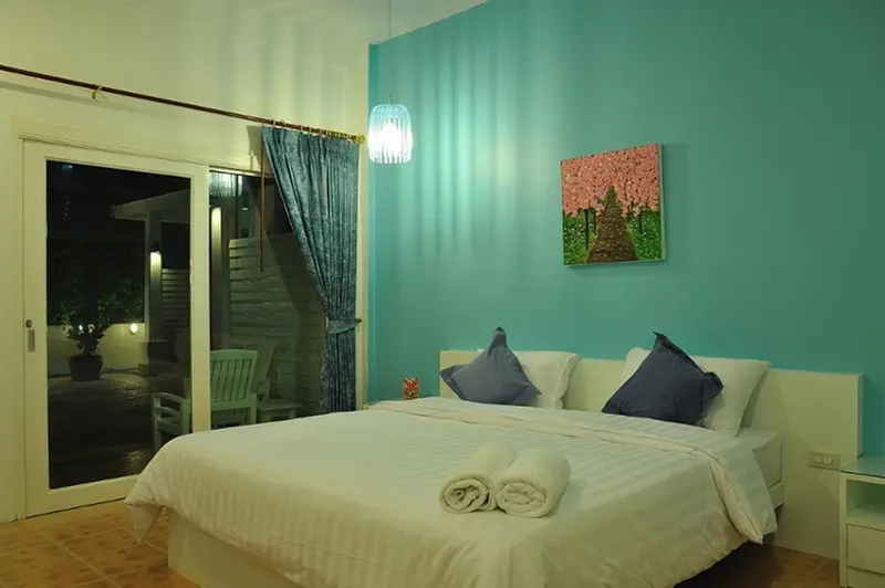 Une chambre lumineuse avec un grand lit et un accès à une terrasse.