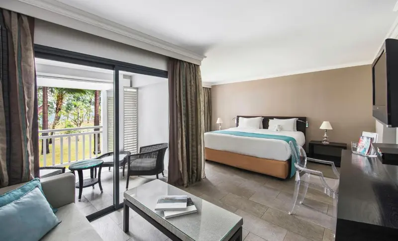 Une chambre lumineuse s'ouvre sur une terrasse avec mobilier.