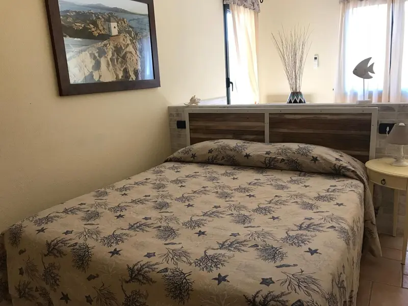 Une chambre lumineuse avec un lit recouvert d'une couette à motifs.