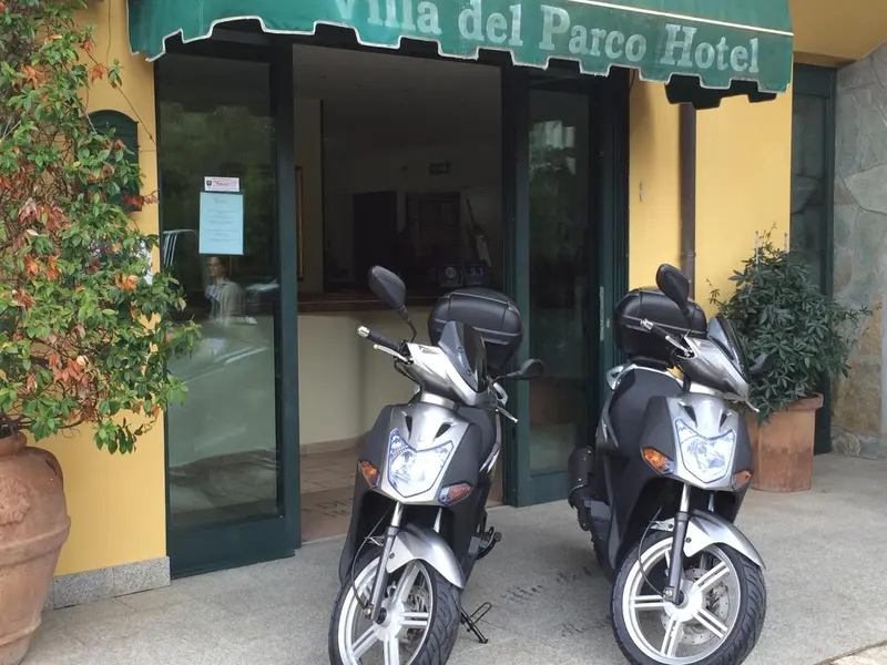 Façade d'hôtel avec des scooters devant l'entrée.