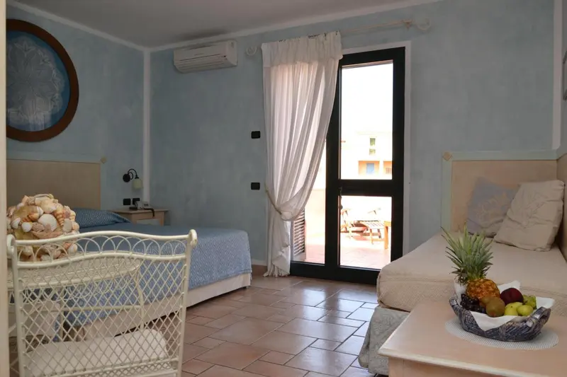 Une chambre lumineuse avec un lit et un coin salon.