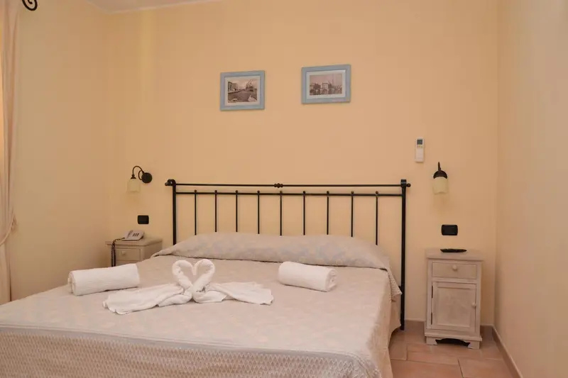 Une chambre lumineuse avec un lit double et des tables de chevet.