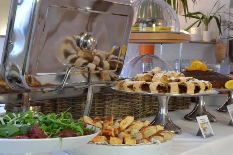 Un buffet propose une variété de pâtisseries, de viennoiseries et de salades.