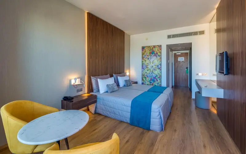 Une chambre lumineuse avec un grand lit et un espace détente.