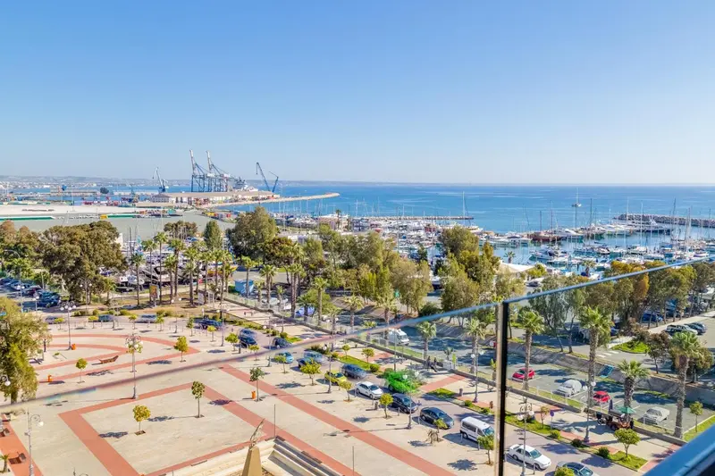 Vue panoramique sur un port de plaisance et la mer depuis un balcon.