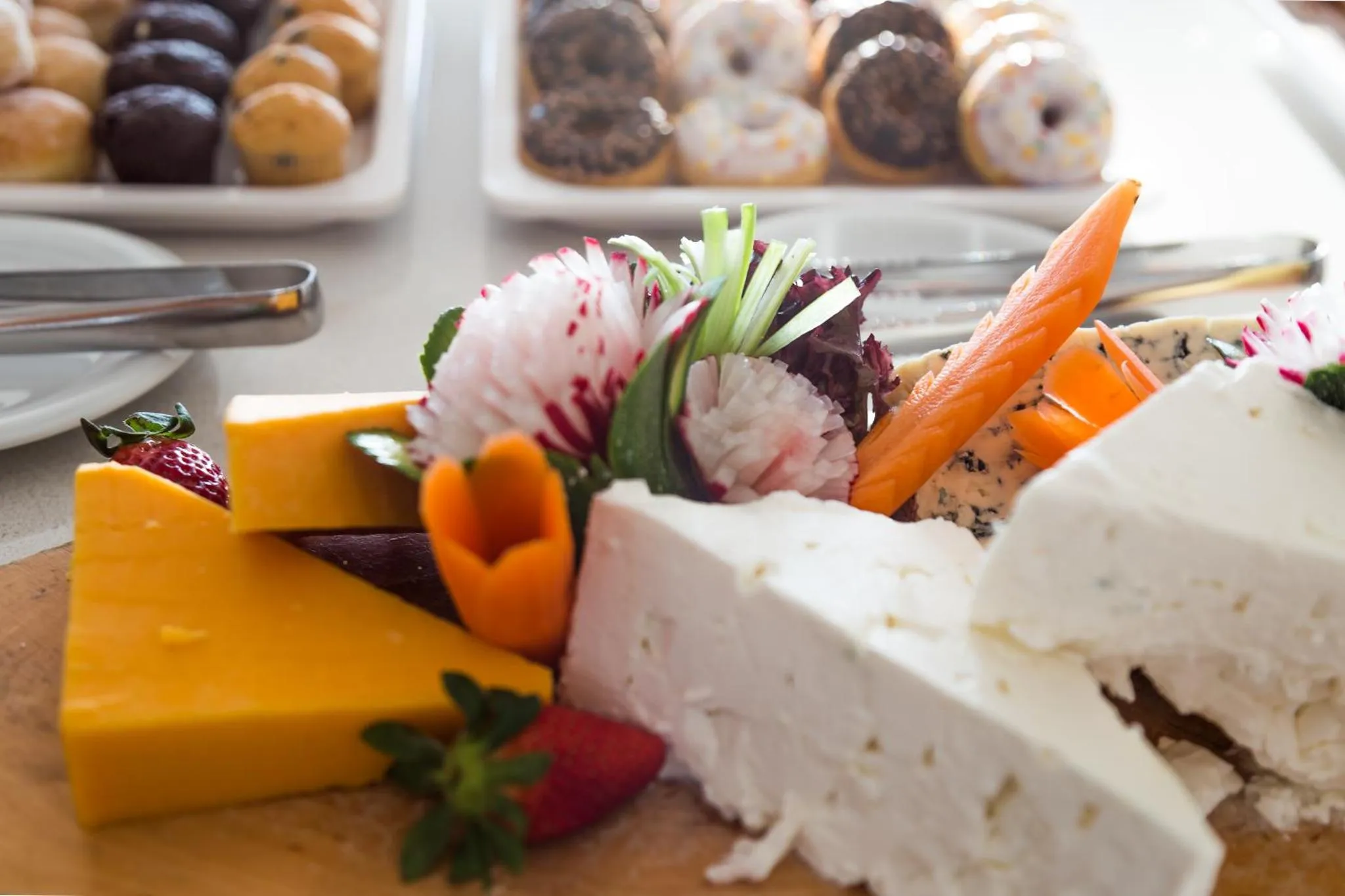 Assortiment de fromages, de charcuteries et de viennoiseries présentés sur un buffet.