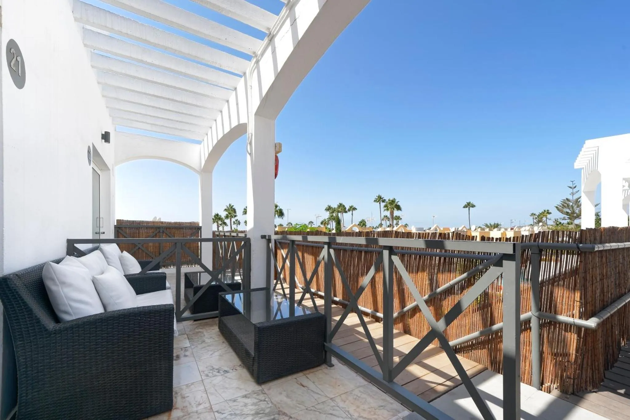 Terrasse aménagée avec canapé et vue sur la mer.