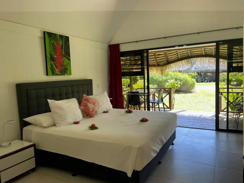 Une chambre lumineuse avec un grand lit et un accès direct sur une terrasse.