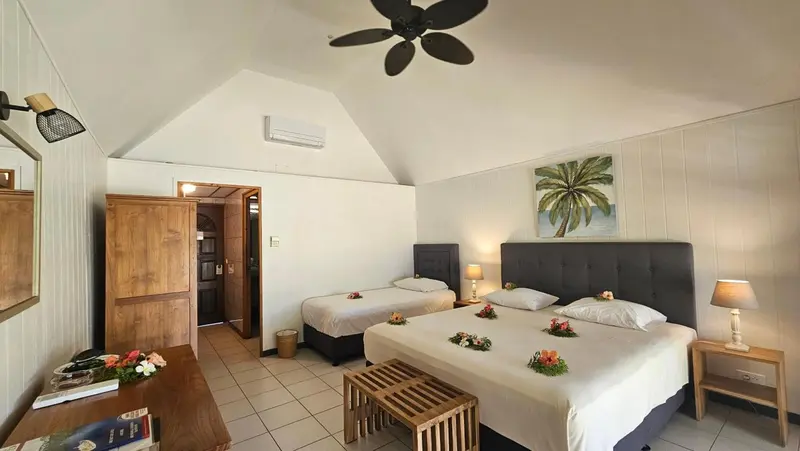 Chambre lumineuse avec deux lits décorés de fleurs.