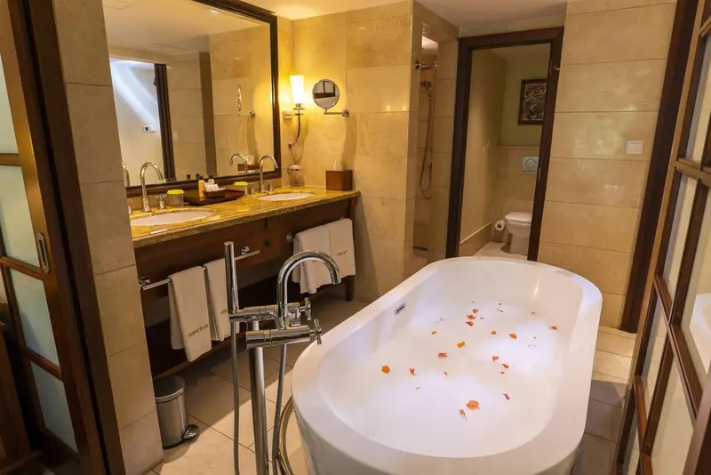 Une salle de bain lumineuse avec baignoire et double vasque.