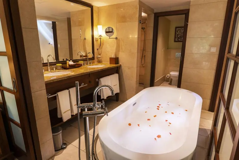 Une salle de bain lumineuse avec baignoire et double vasque.