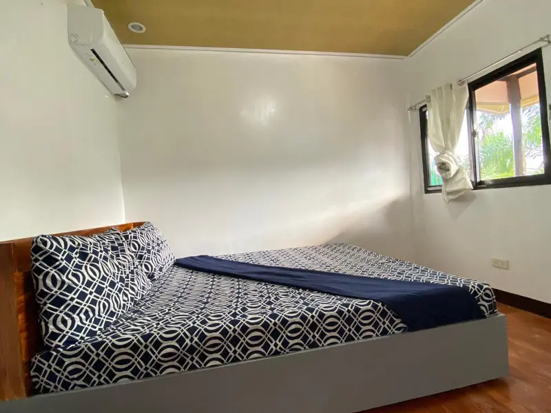 Une chambre lumineuse avec un lit recouvert d'une courtepointe à motifs.