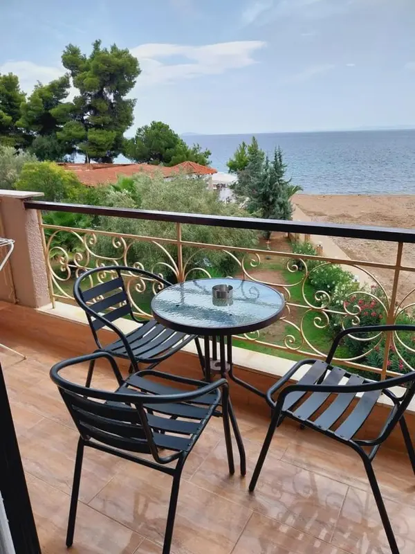Terrasse avec mobilier de jardin et vue sur la mer.
