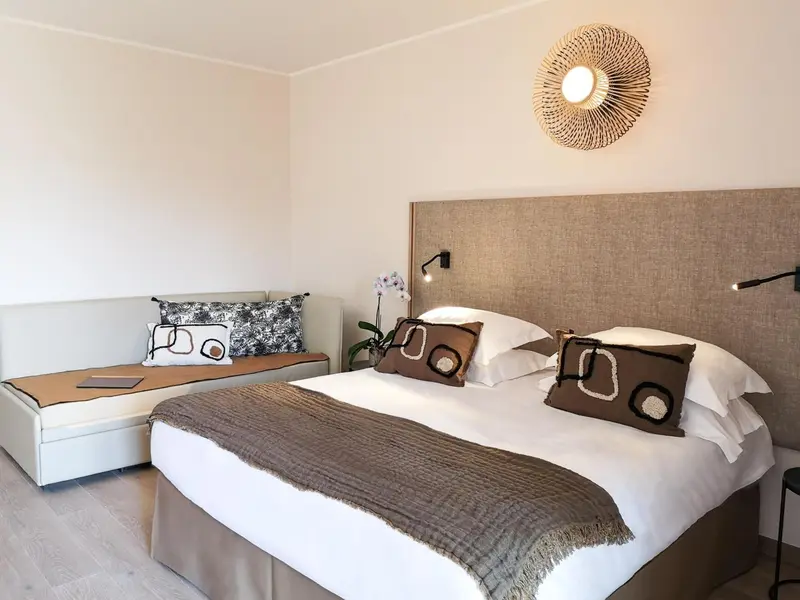 Une chambre lumineuse avec un grand lit et une décoration sobre.