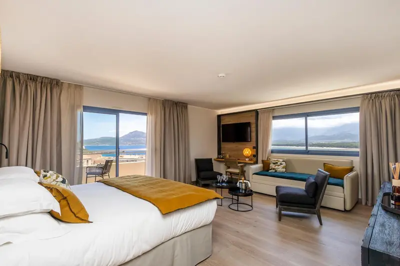 Une chambre lumineuse avec un grand lit et un espace détente.