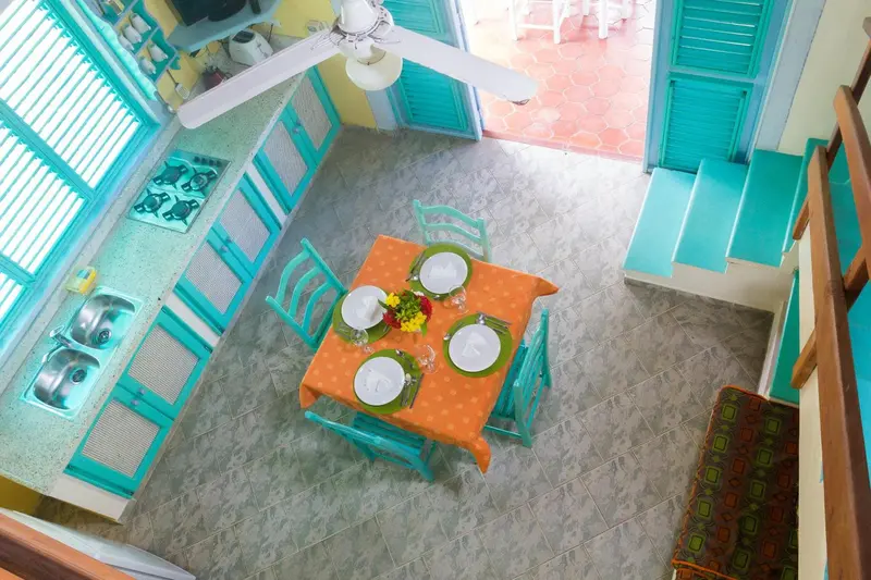 Une table est dressée pour un repas dans une pièce lumineuse et colorée.