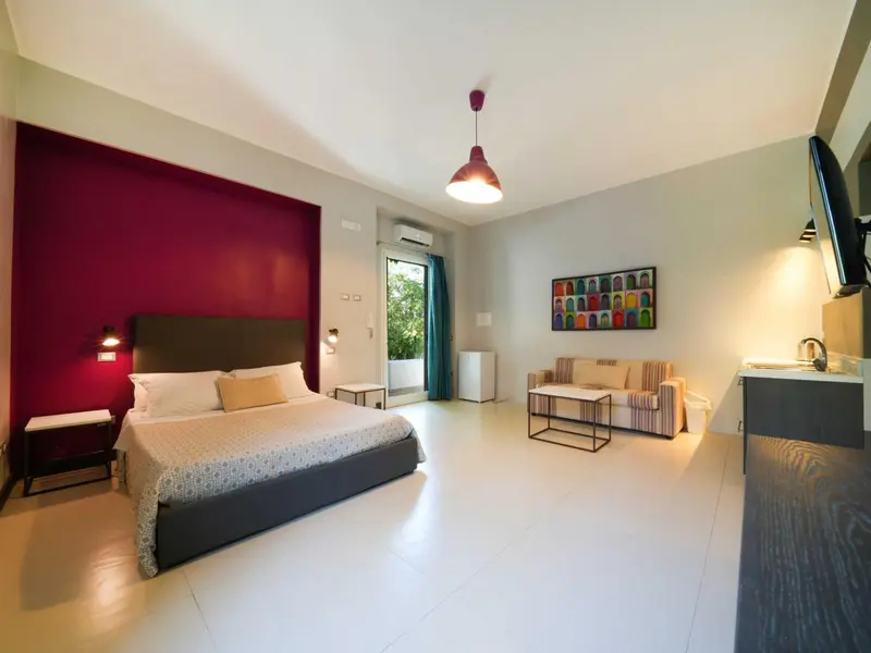 Une chambre lumineuse avec un grand lit et un coin salon.