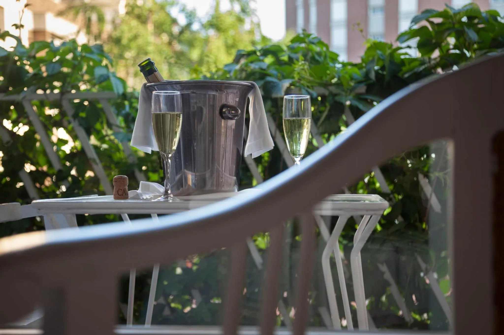 Une table avec des verres et une bouteille de champagne sur une terrasse.