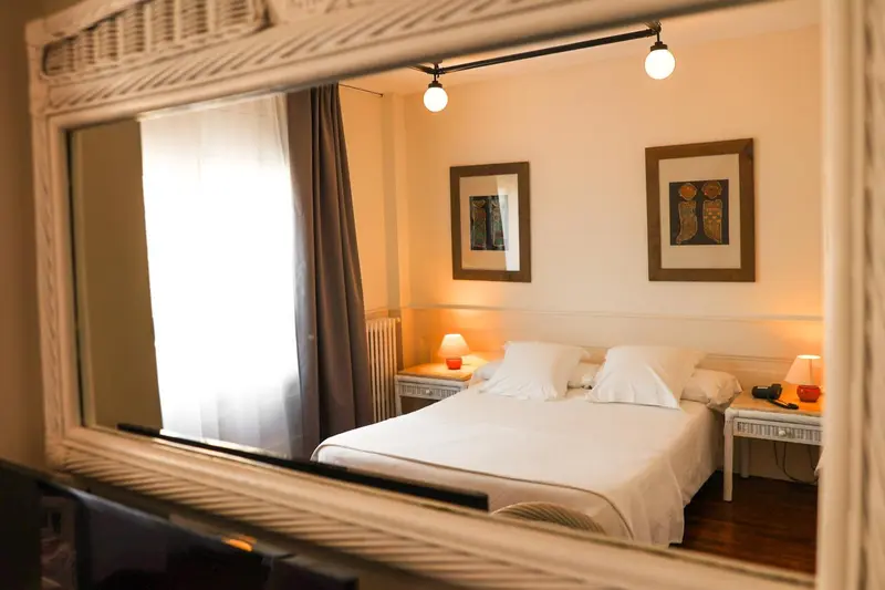 Une chambre lumineuse avec un lit simple et des tableaux décoratifs.