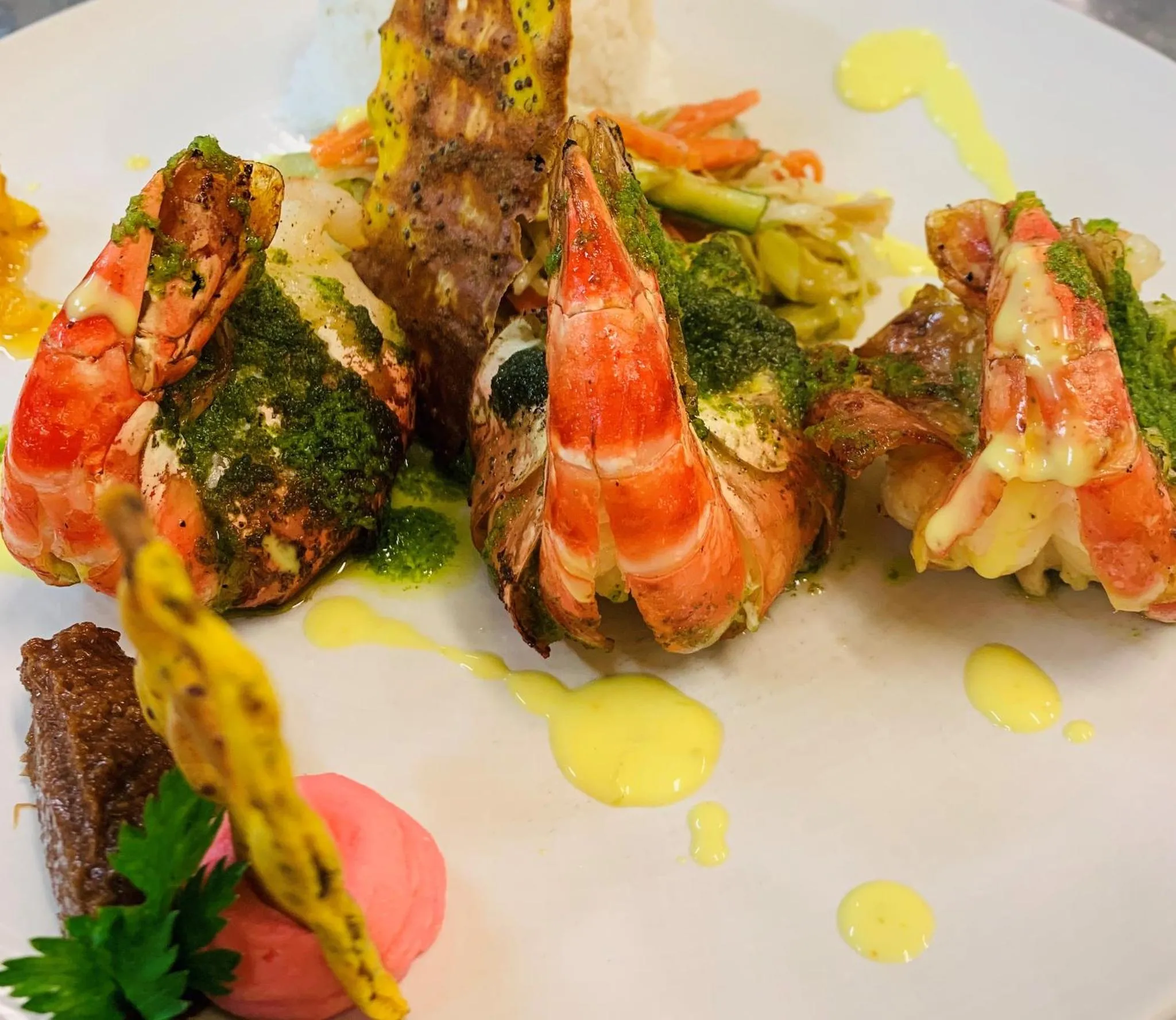 Assiette de fruits de mer avec des crevettes et une sauce colorée.