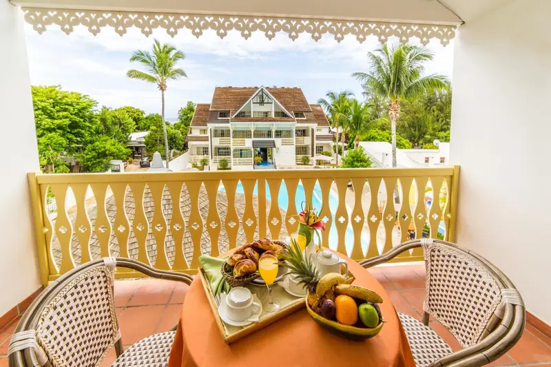 Une table est dressée avec un petit-déjeuner sur une terrasse ensoleillée.