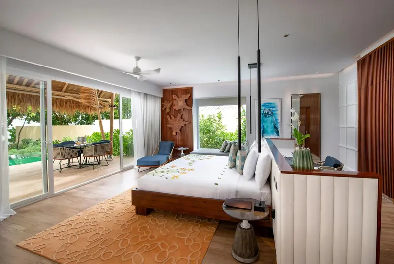 Une chambre lumineuse avec un grand lit et un accès à une terrasse.