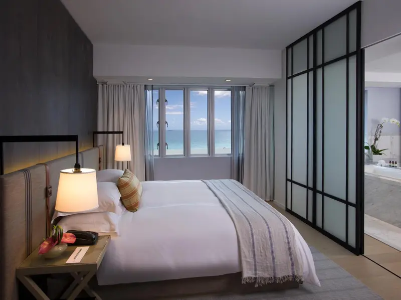 Une chambre lumineuse avec un grand lit face à la mer.
