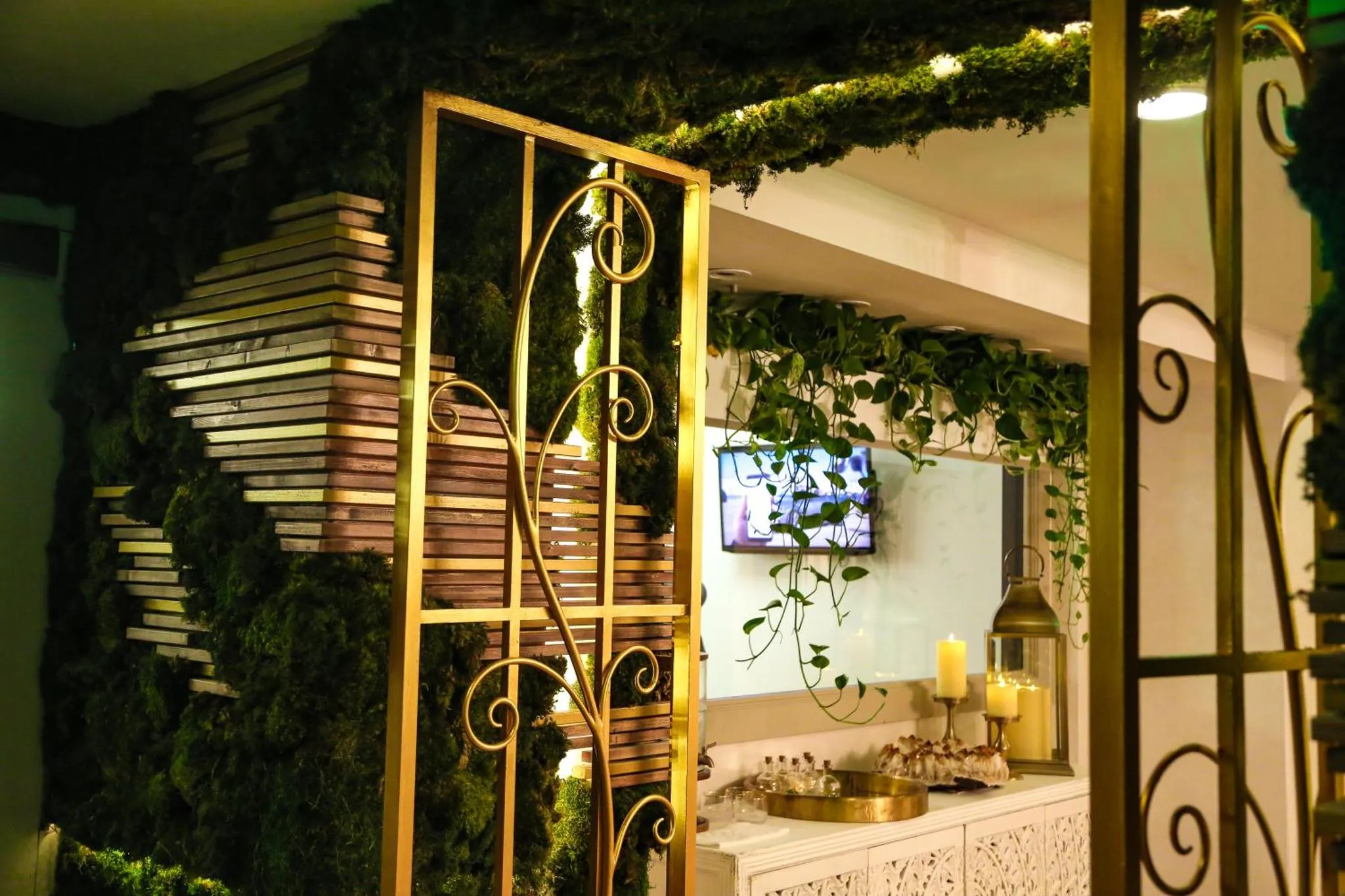 Un espace intérieur décoré de plantes et d'une structure en métal doré.