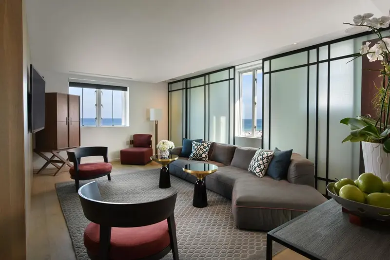 Un salon moderne avec canapé d'angle, fauteuils et table basse.