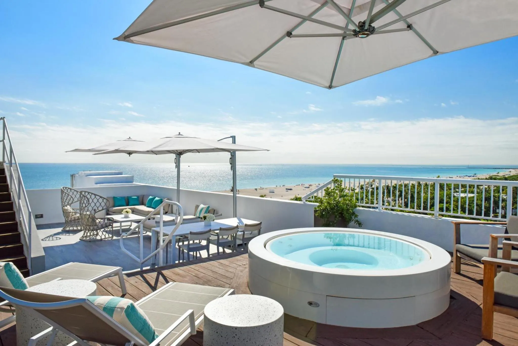 Terrasse aménagée avec salon de jardin et jacuzzi face à la mer.
