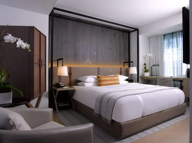 Une chambre lumineuse avec un grand lit et un fauteuil.