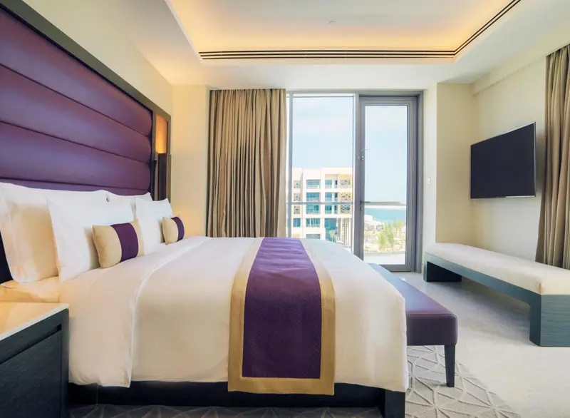 Une chambre d'hôtel moderne avec un grand lit et une vue sur la mer.